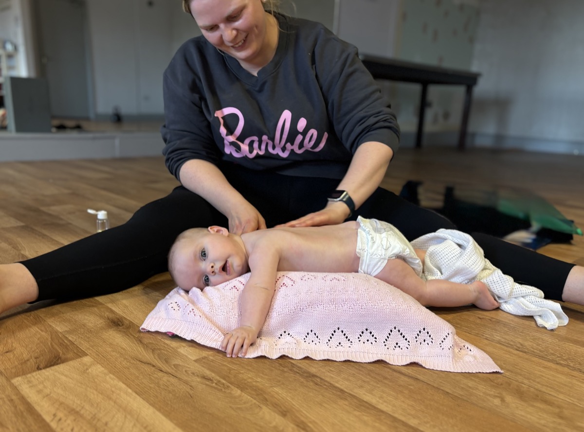 Mother massaging baby